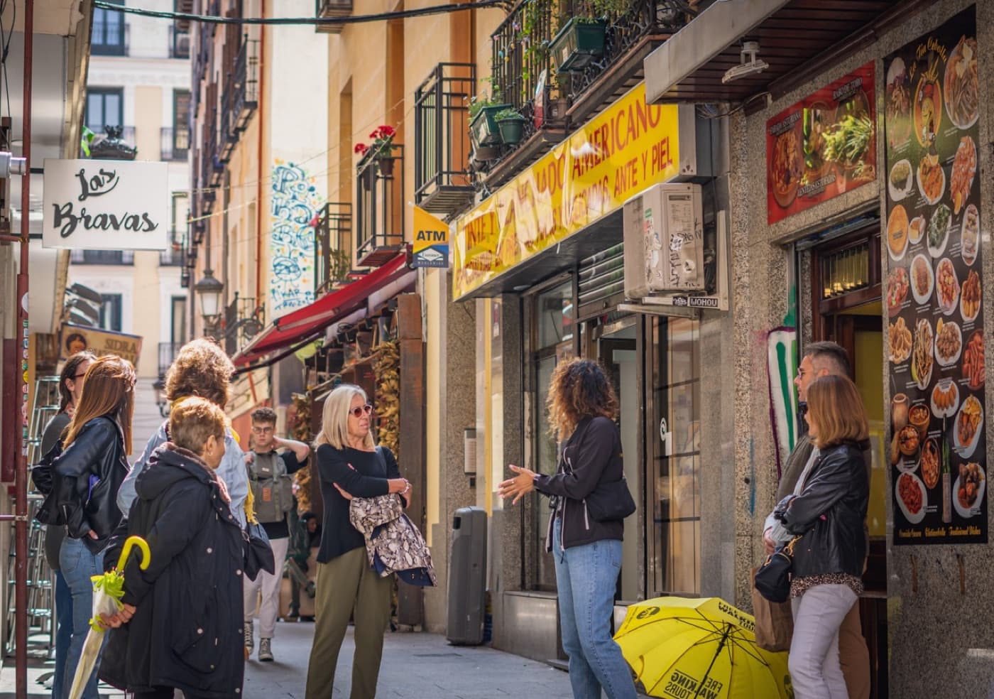 Grupo del free tour con guía local y el paraguas amarillo en una calle del Barrio de las Letras de Madrid